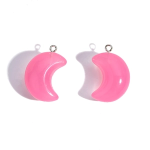 Macro view of pink acrylic moon charms with silver rings for DIY jewelry making projects
