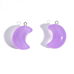 Macro shot of purple translucent acrylic moon charms with silver metal rings for DIY jewelry