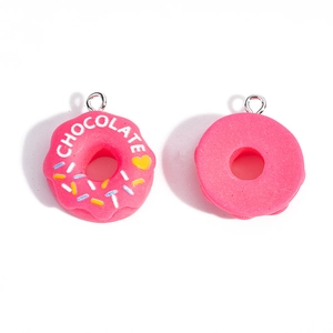 Detalle del colgante de resina rosa con forma de dona con letras chocolate y aro metálico