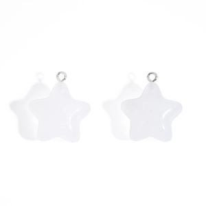 Macro detail of white star acrylic charms with silver metal rings for DIY jewelry