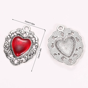 Detailed view of vintage silver heart pendants with red enamel and dimension markings