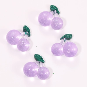 Macro detail of purple resin cherry pendants with glitter for DIY jewelry making