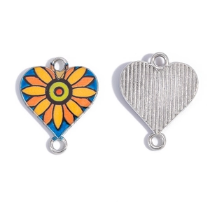 Dettaglio di un ciondolo a cuore in smalto colorato con motivo girasole per gioielli