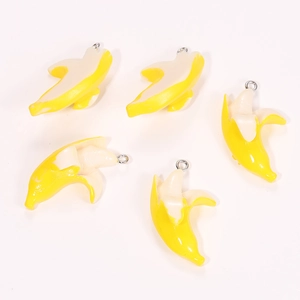 Close-up of five resin banana pendants with metal rings for DIY jewelry making