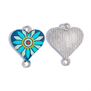 Dettaglio di un ciondolo a cuore smaltato con margherite per la creazione di gioielli DIY