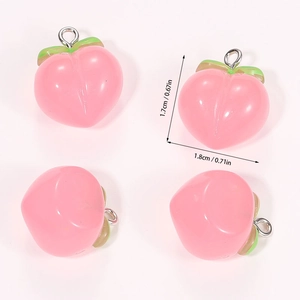 Detailed close-up of cute resin pink peach charms with green leaves for DIY jewelry making
