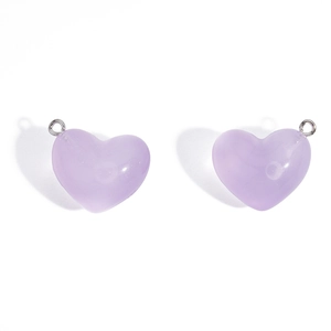 Gros plan de pendentifs cœur en acrylique lavande translucide avec anneaux métalliques argentés