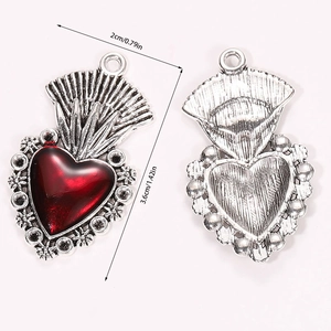Detailed view of Gothic heart pendant with red resin inlay and vintage silver floral patterns