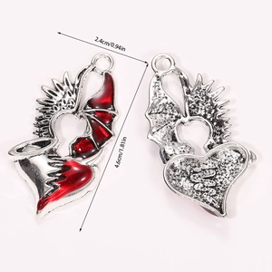 Detailed size view of silver gothic heart pendants with red enamel and wing design details