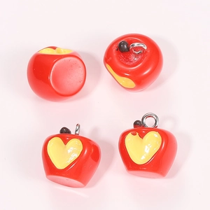 Detailed view of red resin apple charms with yellow hearts for DIY jewelry crafts