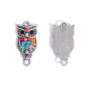 Macro shot of owl jewelry connector with colorful resin beads and metal back texture
