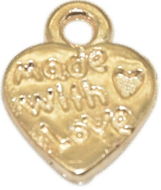 Détail macro d'un pendentif coeur doré avec texte gravé made with love
