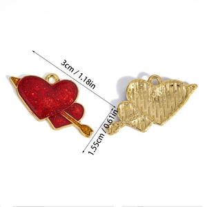 Detaillierte Makroansicht von Herz-Pfeil-Anhänger mit rotem Glitzer und goldenen Rändern