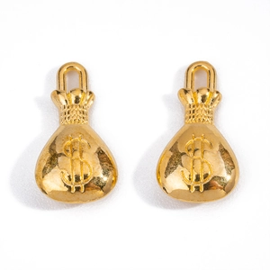 Macro shot of two gold-plated money bag charms with dollar sign symbols for DIY jewelry