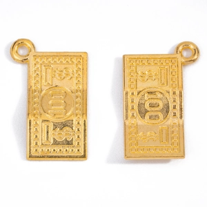 Macro detail of gold-tone alloy 100 dollar bill charms with fine embossed texture