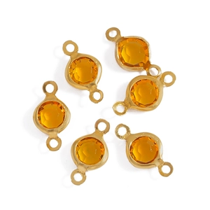 Detail of amber faceted glass connectors with gold-plated copper edges for DIY jewelry making