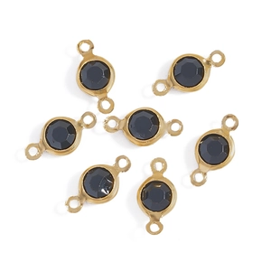Macro detail of gold plated round glass connectors with black faceted stones for DIY jewelry