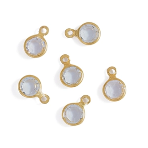 Close-up of 6 round faceted glass charms with gold-plated copper edges for DIY jewelry making