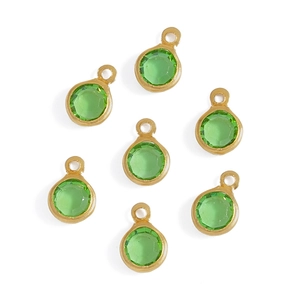 Detailed view of seven round green glass charms with gold-plated metal frames
