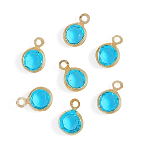Close-up of sky blue faceted round glass pendants with gold-plated copper edges for DIY jewelry