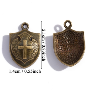 Detail of bronze shield pendants with cross pattern and measurement labels in inches