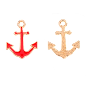 Macro view of double-sided anchor charms showing red enamel inlay and golden alloy finish
