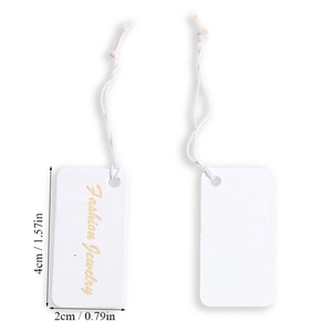 Close-up of a white textured rectangle jewelry tag with gold Fashion Jewelry text and string