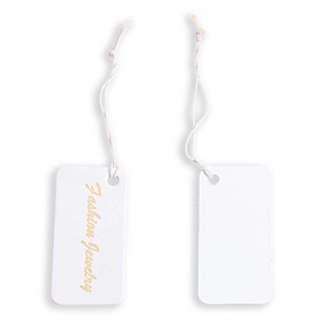 Close-up of white textured cardboard jewelry tags with gold Fashion Jewelry text and strings