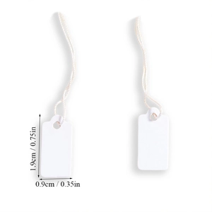 Detailed view of white mini price tags measuring 1.9 x 0.9 cm with attached cotton strings