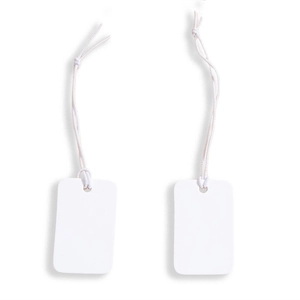 Detail of two white blank paper tags with cotton strings and rounded corners on white background