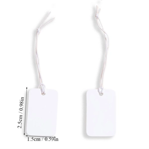 Detailed view of small white blank price tags with strings measuring 2.5x1.5cm for retail