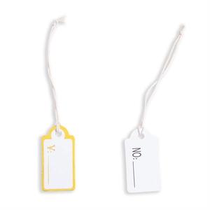 Detail view of small white cardboard price tags with gold currency sign and cotton strings