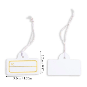 Detail of small white jewelry price tags with yellow borders and white hanging strings