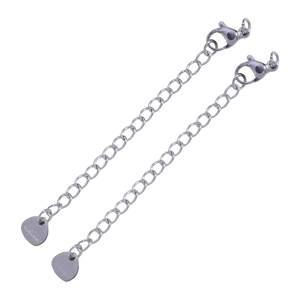 Detailed close-up of two stainless steel extension chains with lobster clasps and heart tags