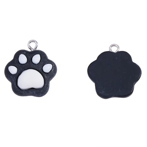 Detail showing the front and back of a black resin cat paw pendant with silver metal ring