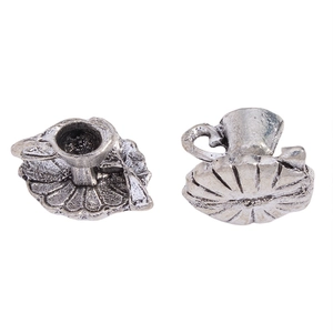 Detailed macro view of vintage silver miniature teacup charms with ornate relief textures