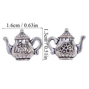 Detailed view of antique silver teapot charms featuring tea time engraving and floral relief
