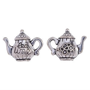 Detailed close-up of antique silver teapot pendants with Tea Time and flower motifs
