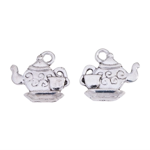 Macro detail of retro alloy teapot pendants with intricate relief swirl patterns