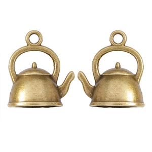 Vue macro de deux breloques théière miniatures en bronze vintage pour bijoux