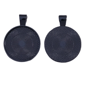 Vue macro de plateaux de pendentifs ronds noirs avec texture concentrique et dos quadrillé