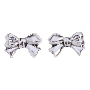 Macro-opname van zilveren strik oorbellen met metallic afwerking en 3D-details op wit