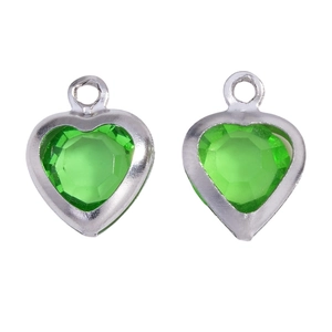Detailed macro of green heart glass charms with silver metal frame for DIY jewelry making