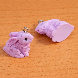 Macro shot of purple resin rabbit charms with flocked texture and silver metal rings