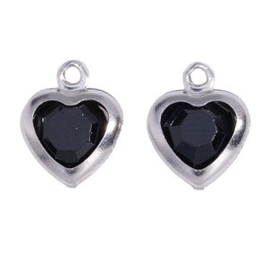 Close-up of black faceted heart-shaped glass pendants with silver frames for DIY jewelry
