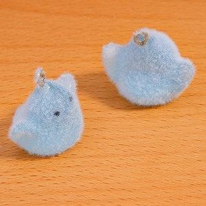 Close-up of soft light blue flocked bird charms with silver metal rings for DIY jewelry