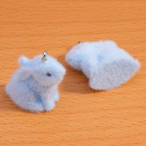 Close-up of light blue flocked rabbit charms with silver rings for DIY jewelry