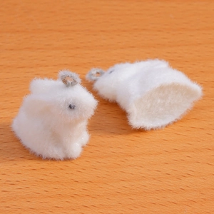 Detail of soft white flocked rabbit charms with silver metal rings for DIY jewelry