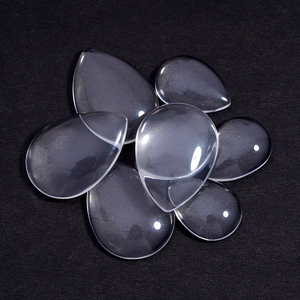 Clear teardrop glass cabochons for DIY jewelry making on a black background
