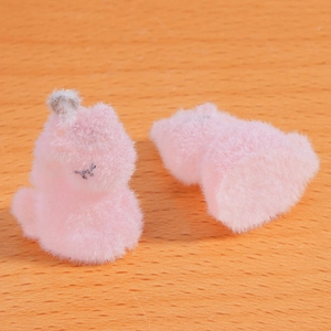 Gros plan de deux figurines chat rose floqué sur surface en bois avec texture pelucheuse